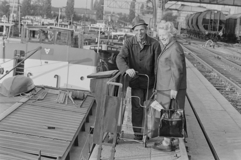 Ein Schiffer-Ehepaar kehrt nach dem Einkauf auf sein Schiff im Basler Rheinhafen zurück, Aufnahme von ca. 1970 (ETH-Bibliothek Zürich, Bildarchiv / Fotograf: Witschi, Hans / Com_L23-0686-0002-0005 / CC BY-SA 4.0)